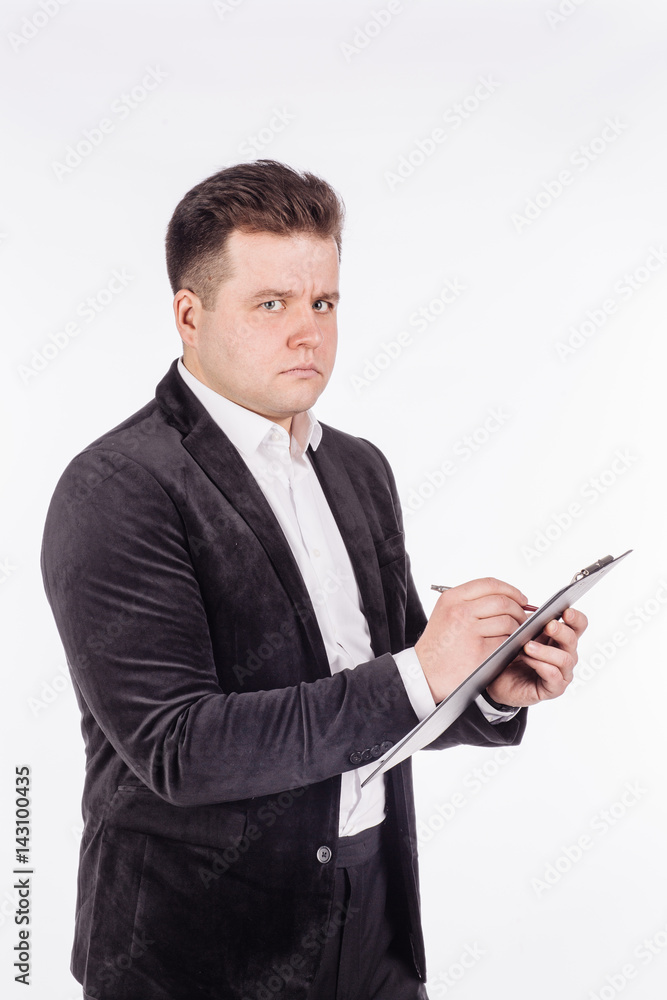 young business man standing and writing in folder on a white background. young business man standing and writing in folder on a white background.