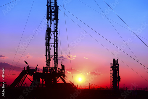 The oil derrick, under the background of the setting sun