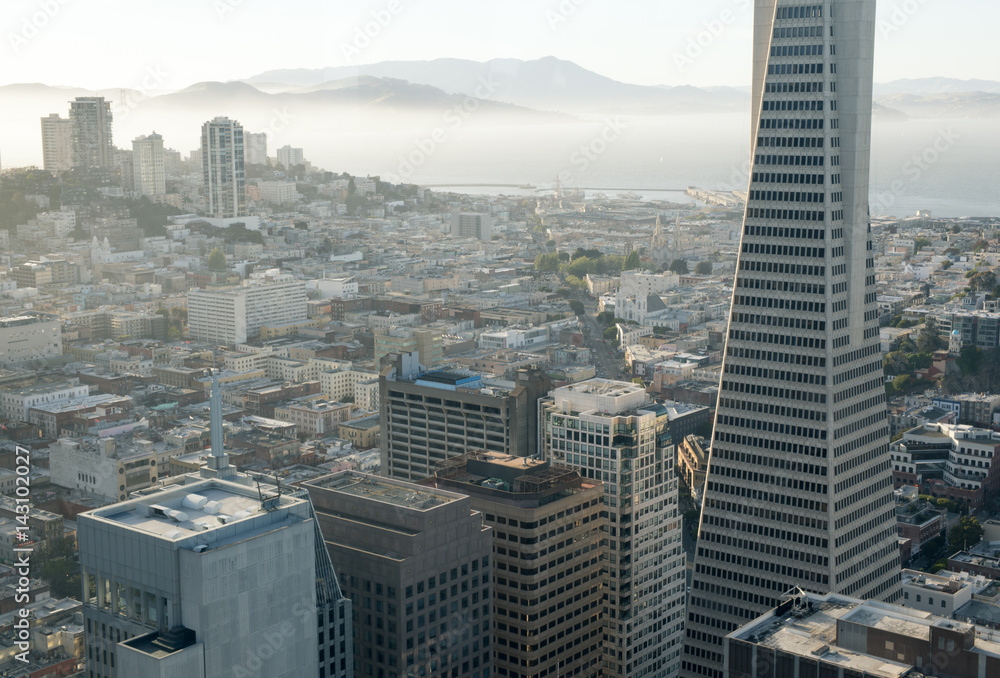 Obraz premium Aerial view of San Francisco Downtown and San Francisco Bay. Financial District neighborhood and hazy San Francisco bay in the background. Taken from a skyscraper's top floor in central downtown.