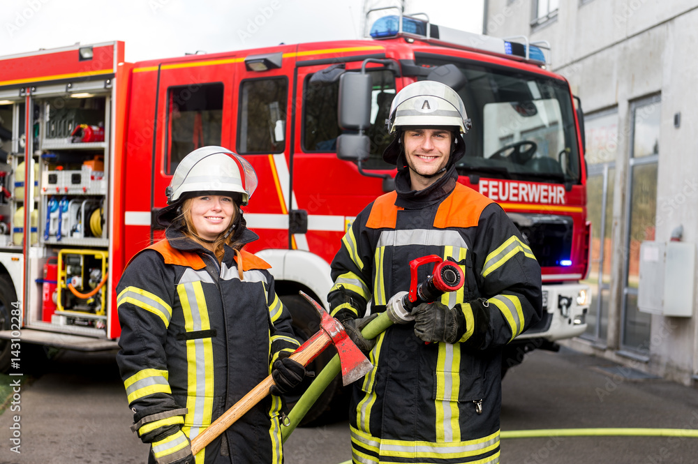 Feuerwehrmann und Feuerwehrfrau an einer Einsatzstelle Feuerwehrmann und Feuerwehrfrau an einer Einsatzstelle
