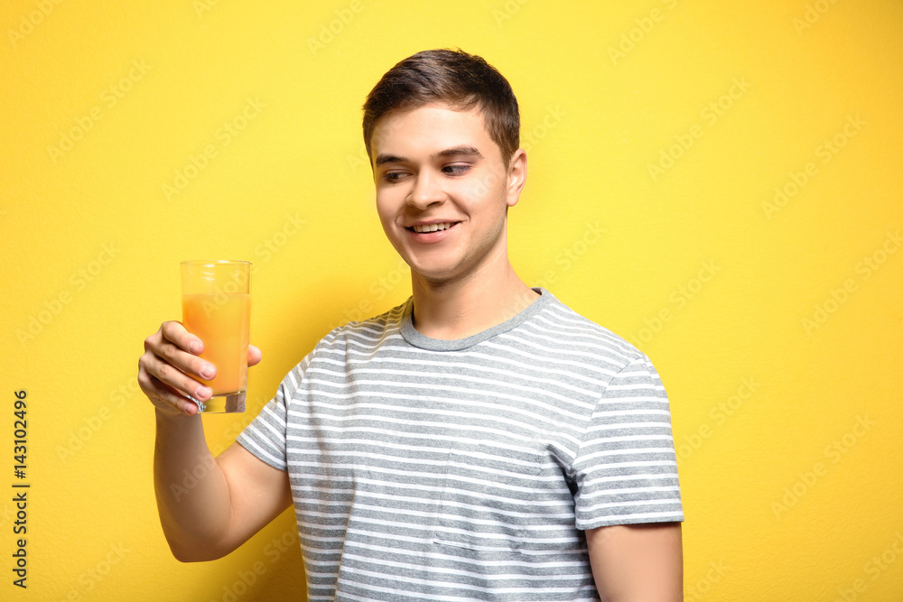 Young man drinking juice on color background Young man drinking juice on color background