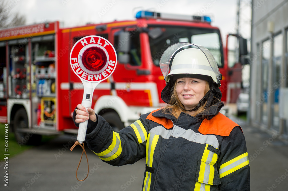 Fototapeta premium Feuerwehrfrau mit Anhaltekelle
