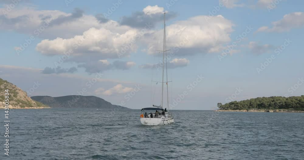 White boat with mast sailing to the open sea. Ship heading to the sea from lagoon, beautiful clouds and islands on the background. White boat with mast sailing to the open sea. Ship heading to the sea from lagoon, beautiful clouds and islands on the background.