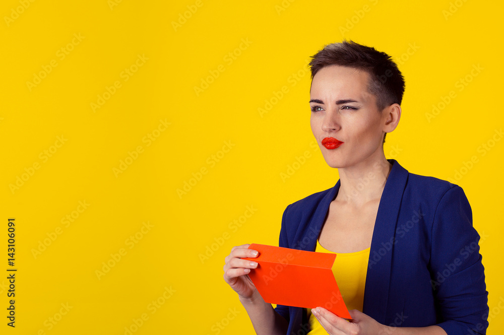 Thoughtful woman holding red envelope with money cash in it thinking what to do next, daydreaming planning how to spend them isolated yellow background wall Thoughtful woman holding red envelope with money cash in it thinking what to do next, daydreaming planning how to spend them isolated yellow background wall
