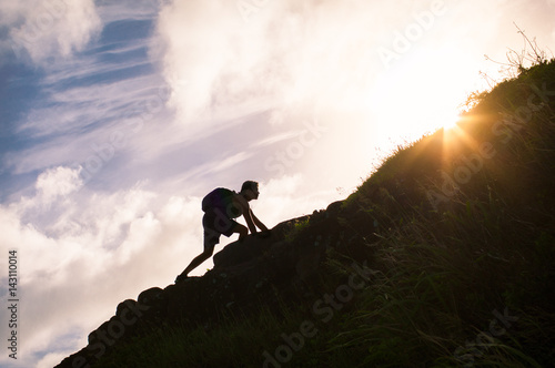 Young man climbing up a mountain. Self improvement and life goals concept.


 photo