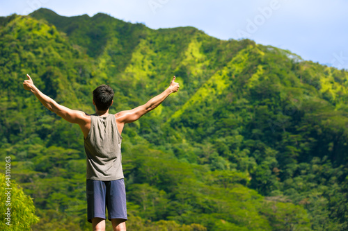Healthy active lifestyle concept. Victorious man outdoors with his thumbs up in the air.