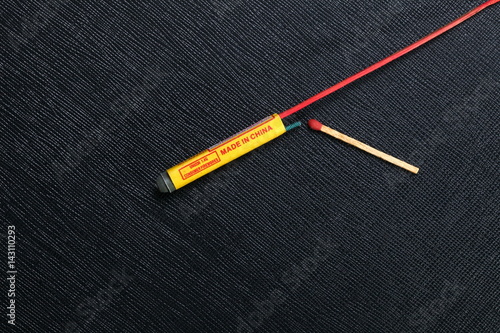 Rocket firework close up photo and classic match stick put on the black color leather surface as a background represent the celebration explosive material.