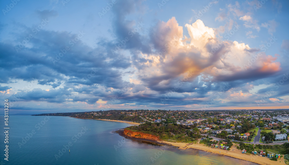 Aerial panorama of coastline, beaches and Australian suburban area at sunset with beautiful clouds. Mornington Peninsula, Melbourne, Victoria, Australia