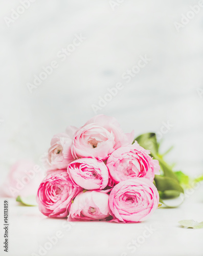 Light pink spring ranunkulus flowers on marble background, selective focus, copy space. Spring greeting card concept