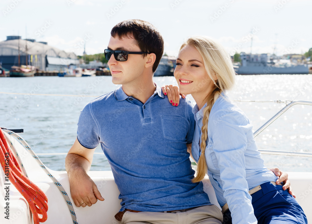 Happy and beautiful young couple having a rest on a yacht. Traveling, tourism, journey, concept.