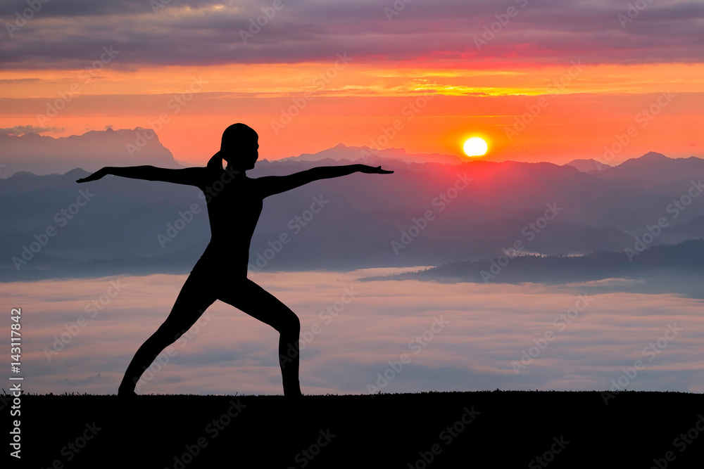Woman practicing warrior yoga pose outdoors at nature background.