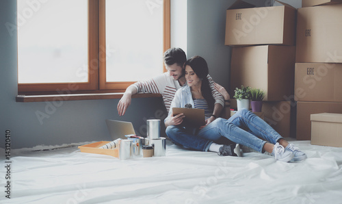 Obraz na plátně Young couple sitting on the floor of their new apartment