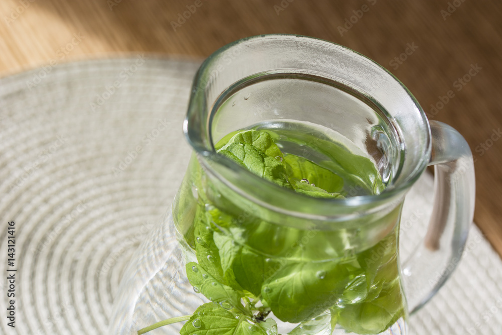 Glass jug with water and mint leaves. Glass jug with water and mint leaves.