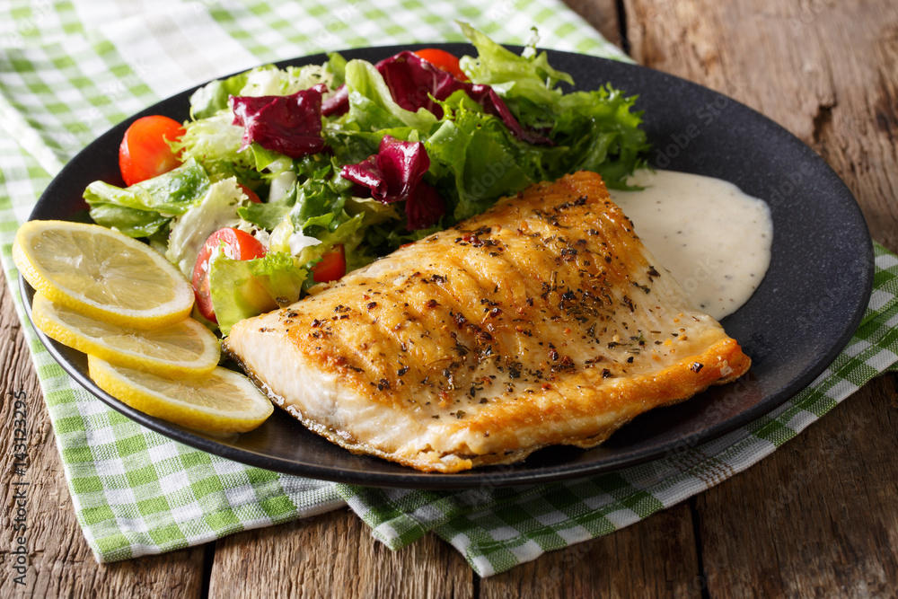 Grilled char fillet with mixed salad and sauce on a plate close-up. horizontal Grilled char fillet with mixed salad and sauce on a plate close-up. horizontal