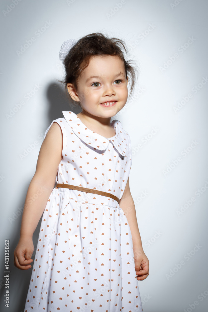 Portrait of 3 year old little girl with dress, smiling and posing on bright white background Portrait of 3 year old little girl with dress, smiling and posing on bright white background