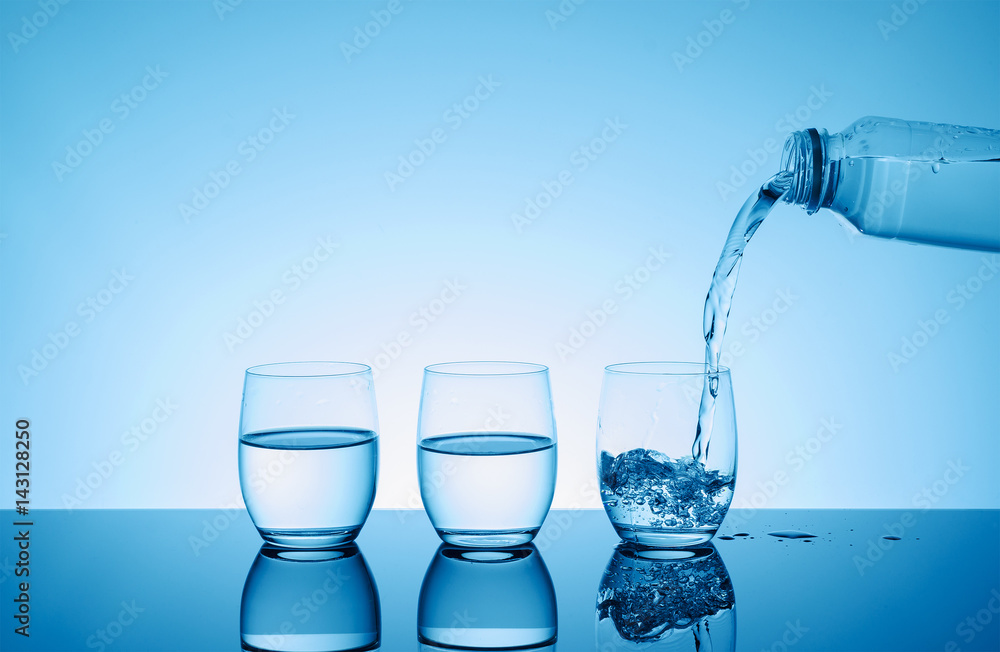Bottle with creative splashing water in the glass Bottle with creative splashing water in the glass
