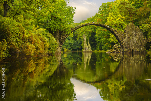 Autumn, cloudy evening over Devil's bridge in the park Kromlau, Germany