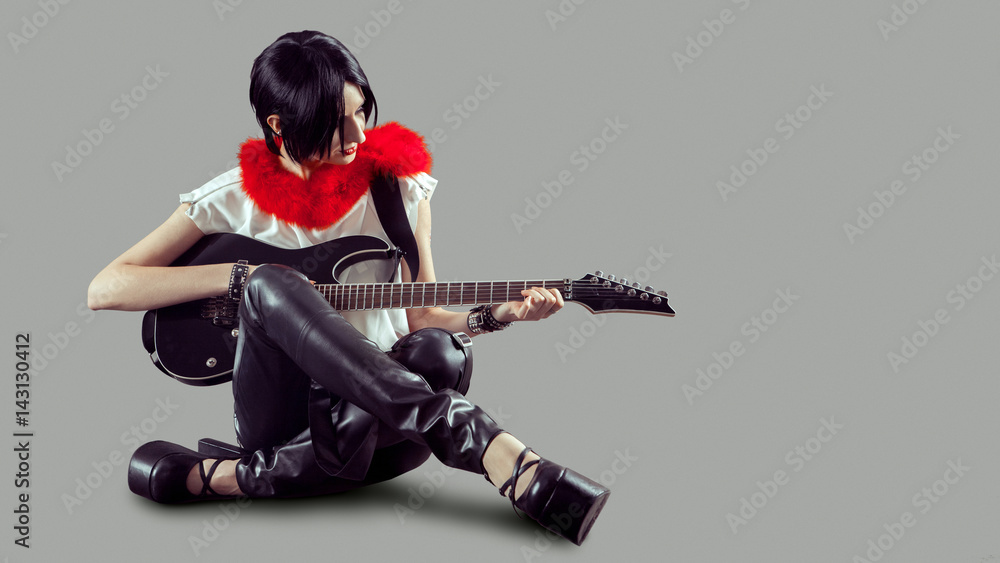Fototapeta premium Young attractive rock girl playing the electric guitar