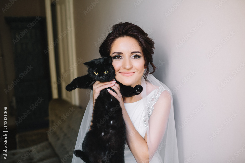 Pretty brunette bride holds black cat in her arms Pretty brunette bride holds black cat in her arms