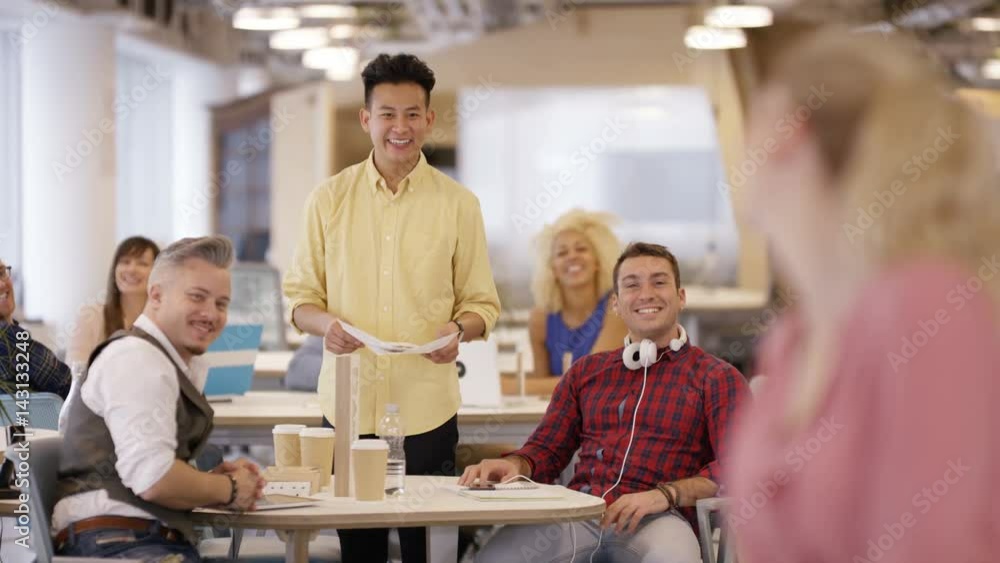 Portrait smiling businesswoman in office with colleagues working in background Portrait smiling businesswoman in office with colleagues working in background
