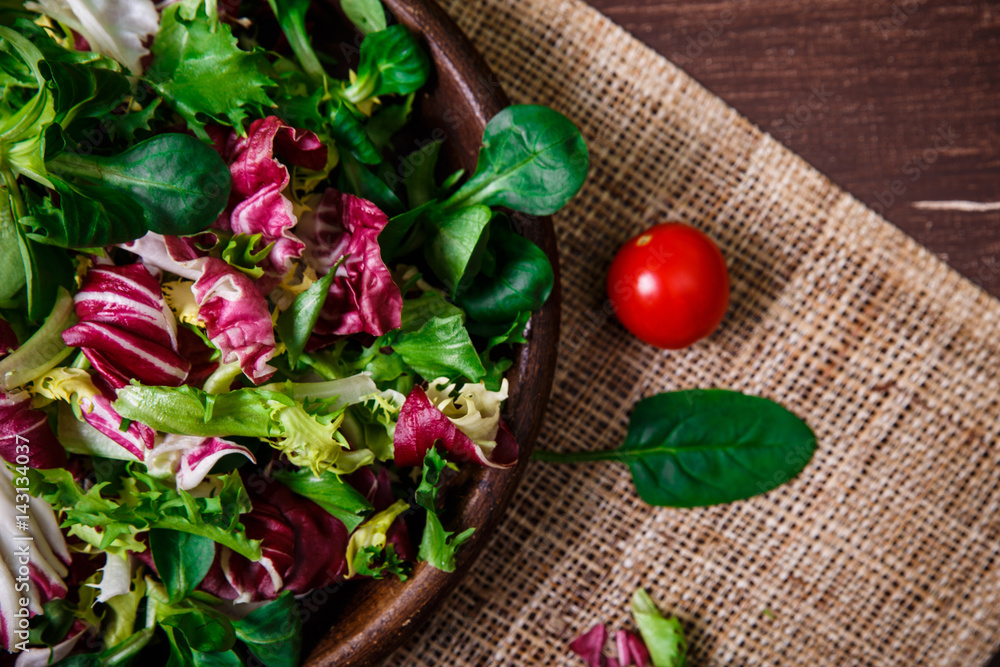 Provence salad. Leaves of endive or chicory, lamb and rose salad. Cherry tomato. Raw vegetables. On wooden table. Provence salad. Leaves of endive or chicory, lamb and rose salad. Cherry tomato. Raw vegetables. On wooden table.