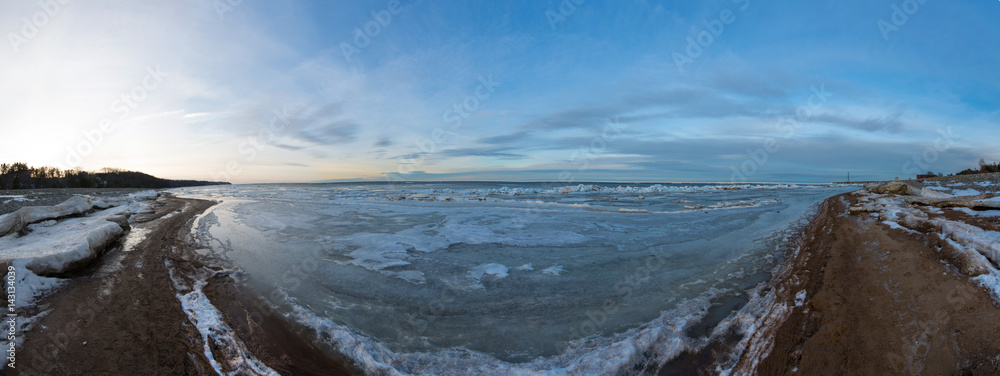Winter landscape. Coast line. Sea covered blocks of ice. Panorama.