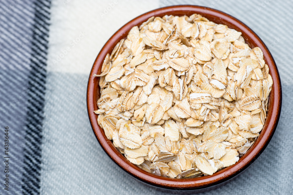 Dry rolled oat flakes oatmeal in a old bowl Dry rolled oat flakes oatmeal in a old bowl