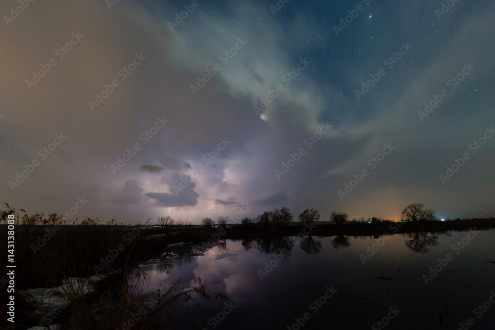 Fototapeta premium Rain and lightning above the river