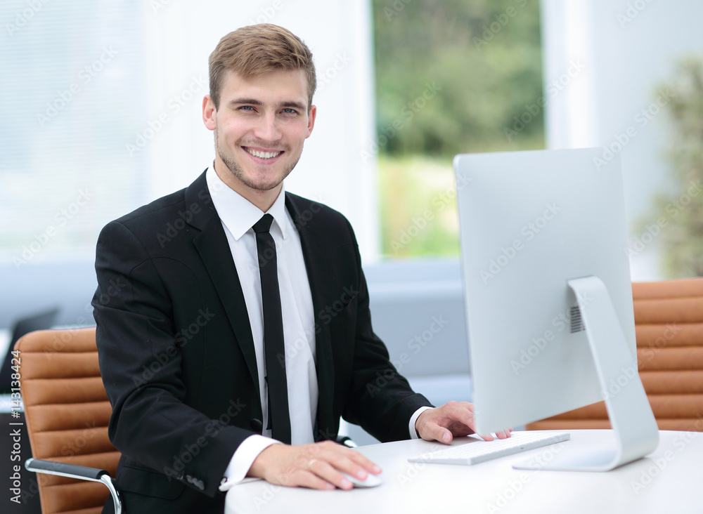 Smiling business man working on computer in a modern office Smiling business man working on computer in a modern office