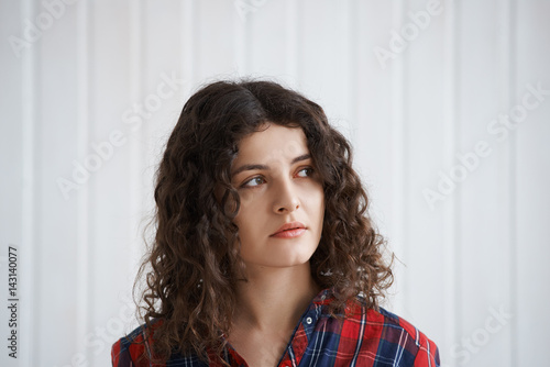 portrait of attractive european Curly hair woman in red check shirt look to the side. Student girl dream about new exciting trip in summer season after university. Time to be free.