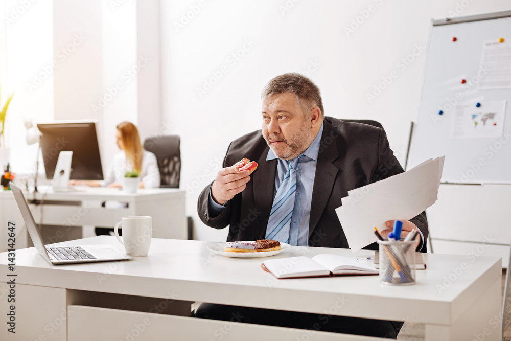 Excessive tired worker having an unhealthy snack