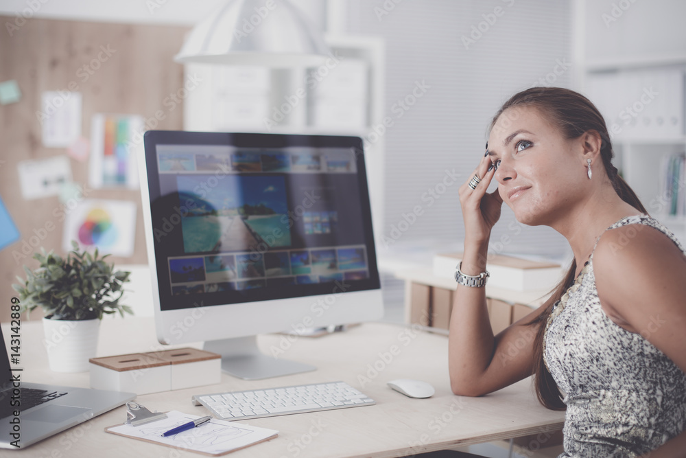 Fashion designers working in studio sitting on the desk Fashion designers working in studio sitting on the desk