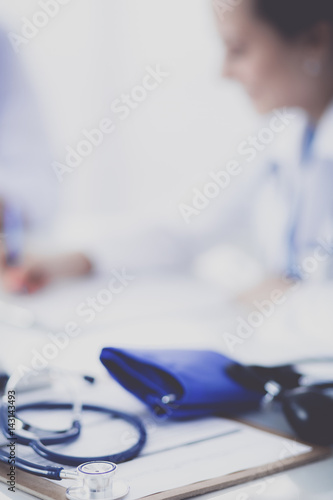 Portrait of young female doctor sitting at desk in hospital
