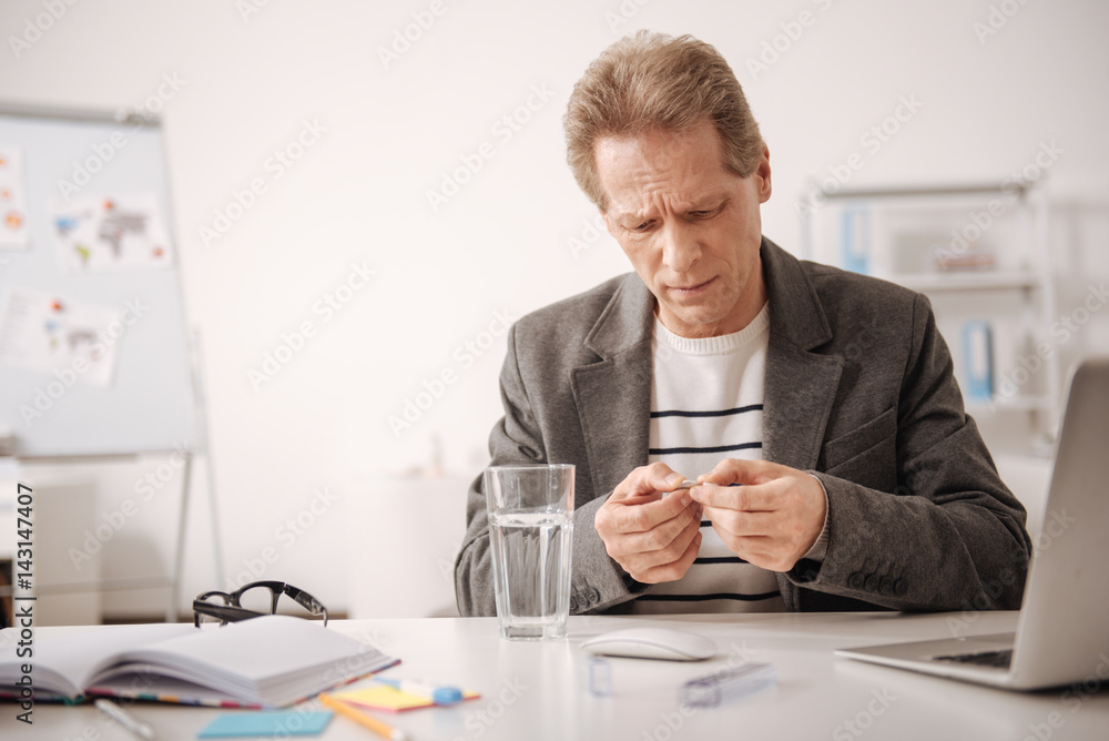 Aged office manager suffering from high pain in the office Aged office manager suffering from high pain in the office