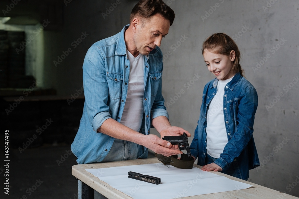 Pleasant nice man looking at the disassembled gun Pleasant nice man looking at the disassembled gun