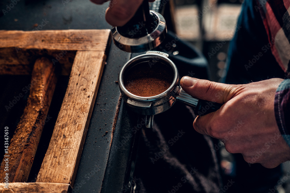  Close up image of a man making coffee.