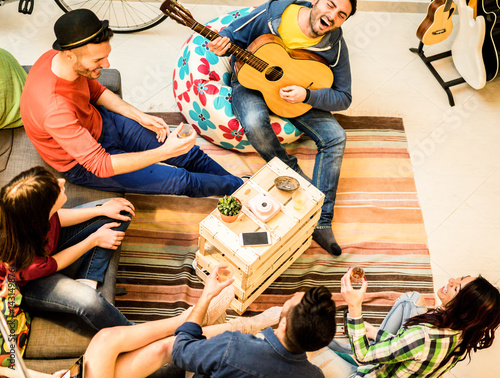 Group of trendy friends having fun in hostel living room photo
