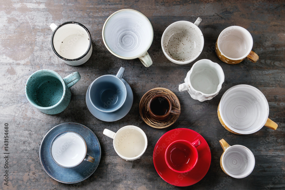 Empty colorful modern ceramic plates and bowls collection. Various of dishware over dark metal background. Top view Empty colorful modern ceramic plates and bowls collection. Various of dishware over dark metal background. Top view