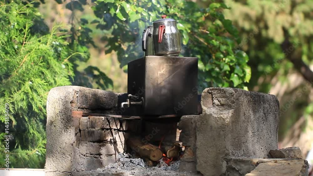 Teatime in nature at amazon camp. Boiling water in a large container over campfire. Preparing tea over campfire in nature. Teatime in nature at amazon camp. Boiling water in a large container over campfire. Preparing tea over campfire in nature.