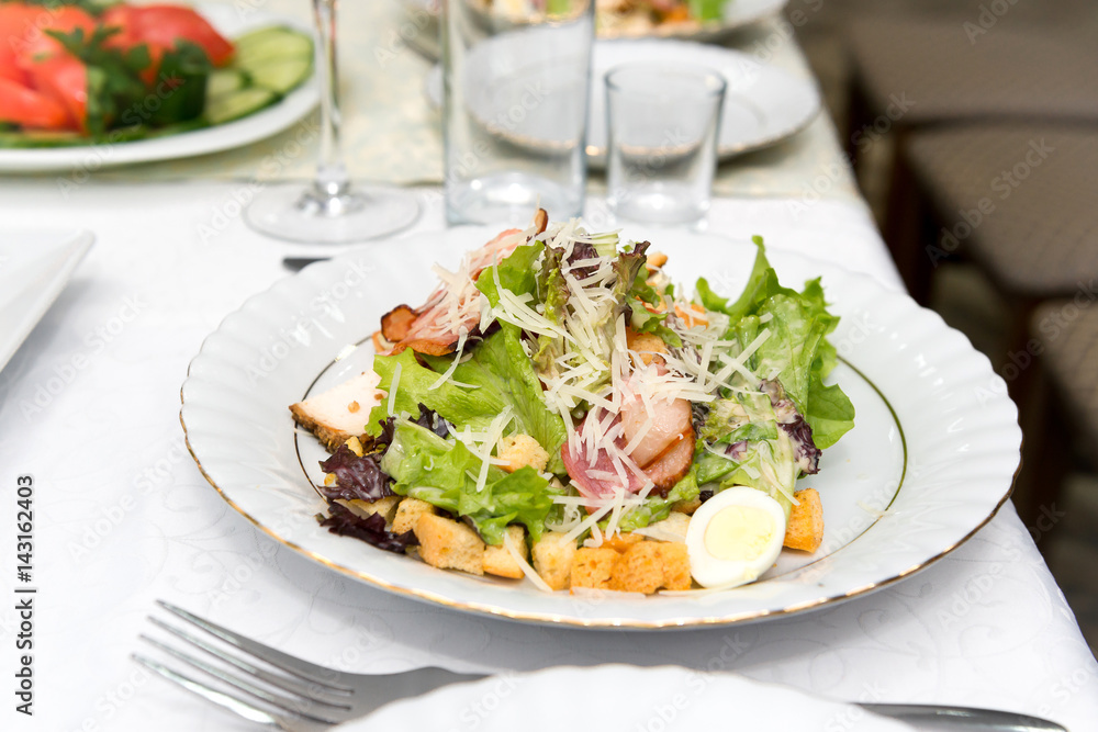 Caesar salad with fried meat, bacon, egg, croutons and lettuce leaves. Caesar salad with fried meat, bacon, egg, croutons and lettuce leaves.