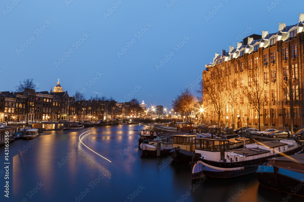 Amsterdam, March 17, 2017: Canals and house view from Amsterdam, during the twilight where city of bikes, canals and peace