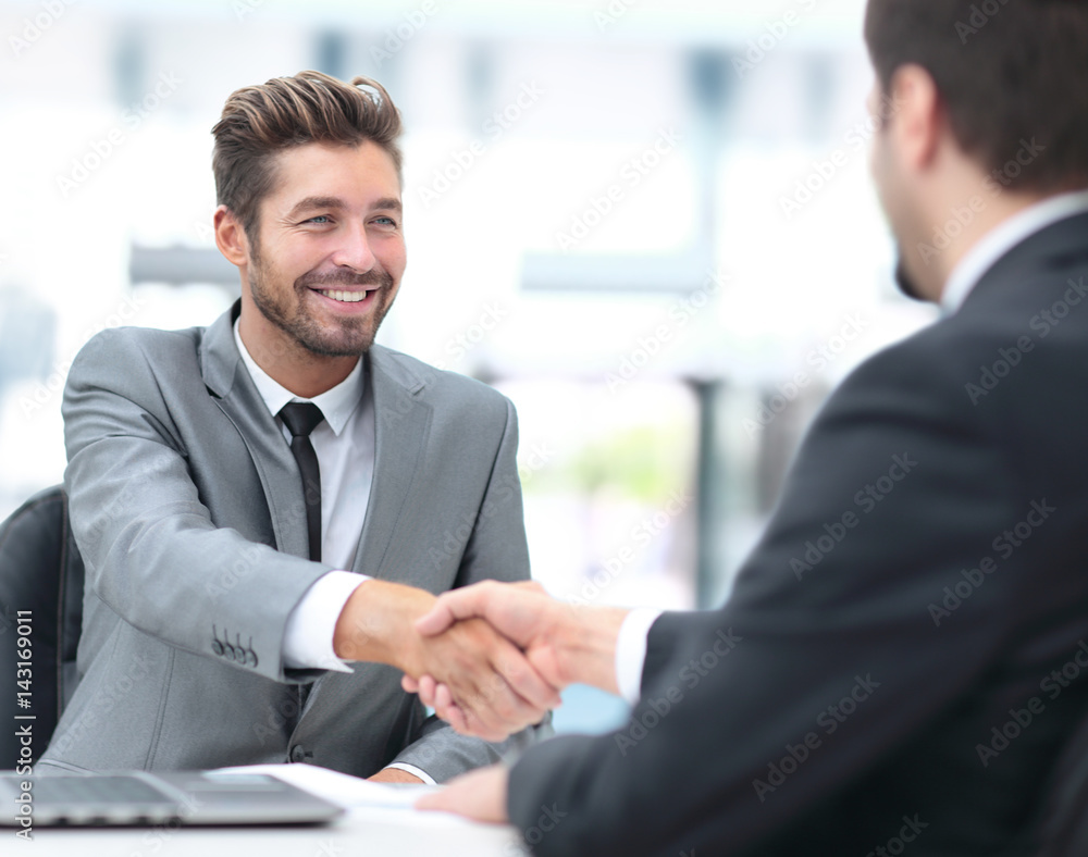 Two business people shaking hands and looking at each other with Two business people shaking hands and looking at each other with
