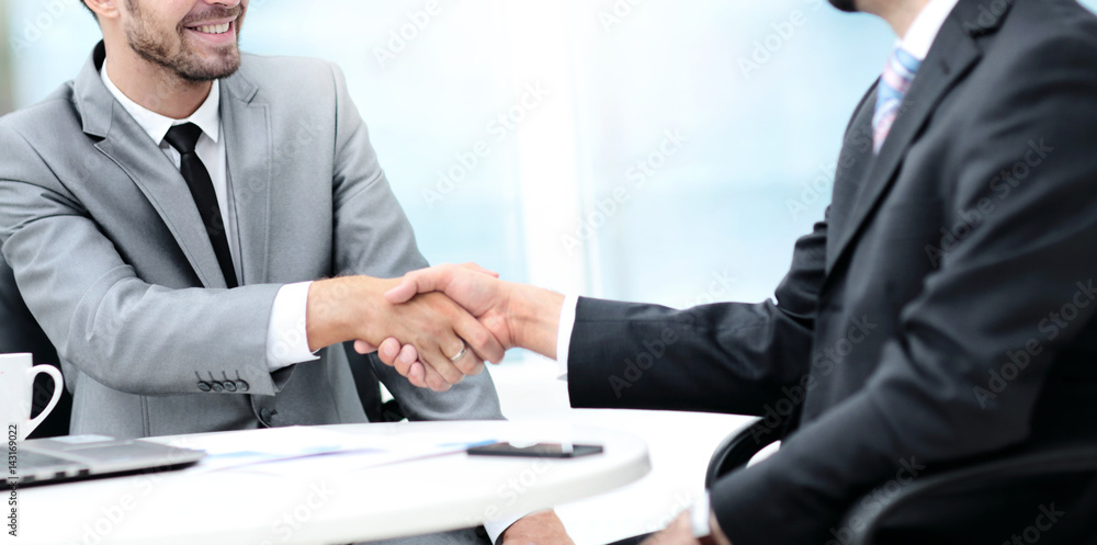 Business handshake. Two business people shaking hands in office. Business handshake. Two business people shaking hands in office.