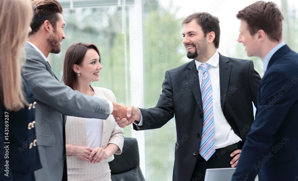 Two business people shaking hands at the business meeting with t Two business people shaking hands at the business meeting with t
