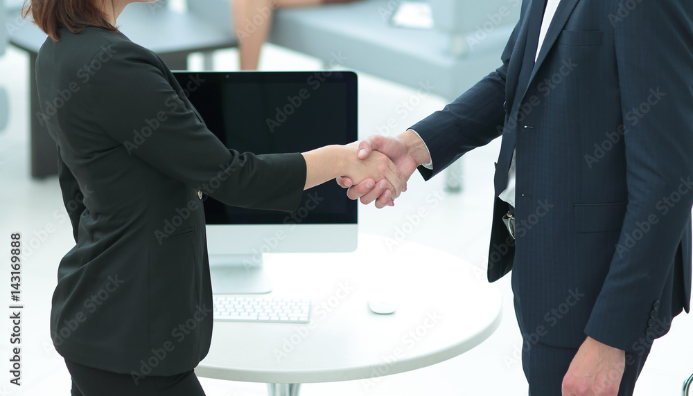 Two business people shaking hands with each other in the office Two business people shaking hands with each other in the office