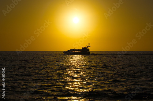 Silhouette of a ship at sunset. © Maxim Tsvetinskiy