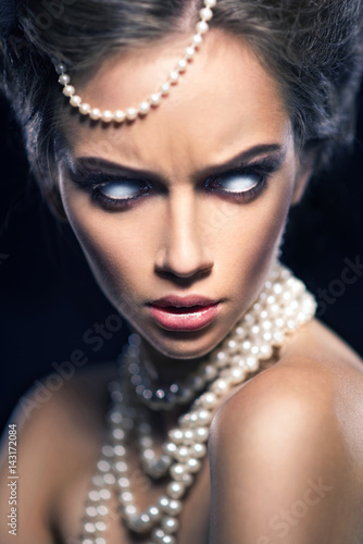 Beautiful woman with jewelry pearls and white eyes.