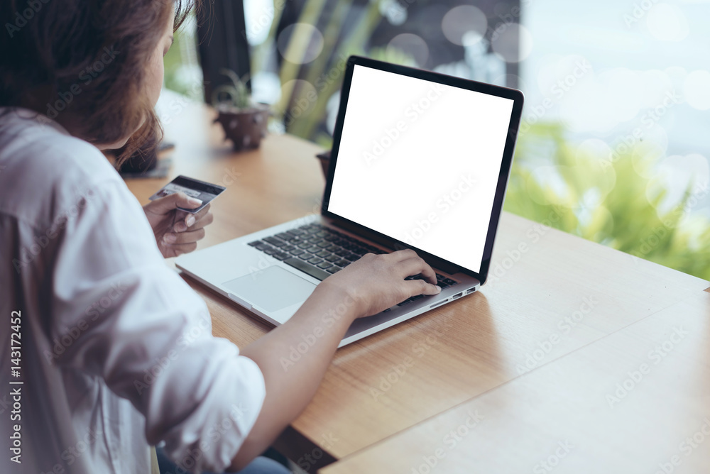 Asian Woman holding credit card and typing keyboard on blank screen laptop with shopping online in selective focus. Asian Woman holding credit card and typing keyboard on blank screen laptop with shopping online in selective focus.