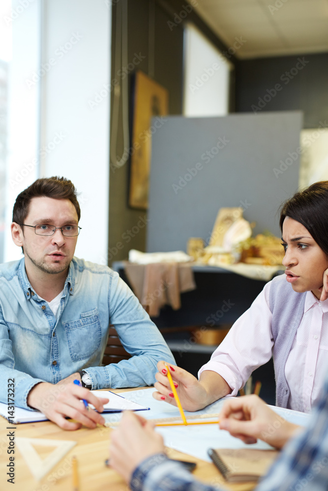Young specialists having discussion of business project Young specialists having discussion of business project