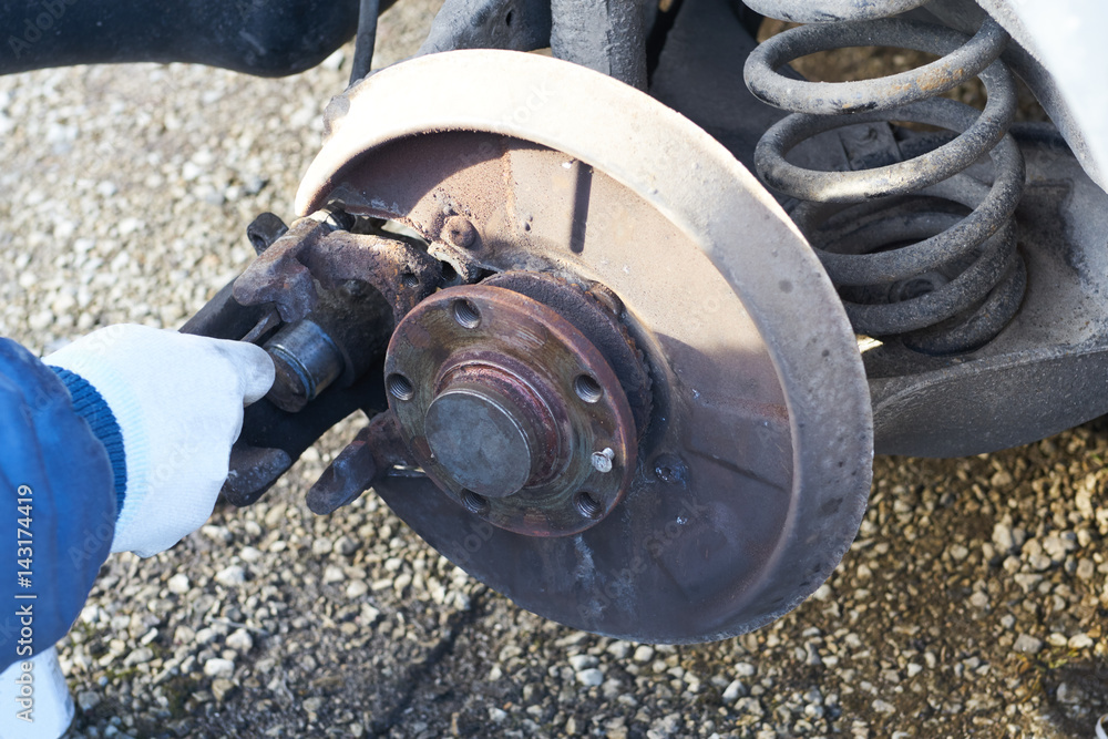 Mechanic hand during maintenance of a caliper brake of a car